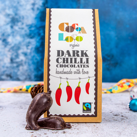 Cocoa Loco organic dark chocolate Fairtrade chillies on a white and blue background next to some Christmas decorations