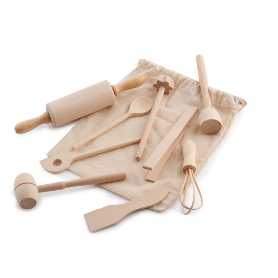 Evolving wooden mini kitchen utensil set laid on and around its natural cotton bag, on a white background