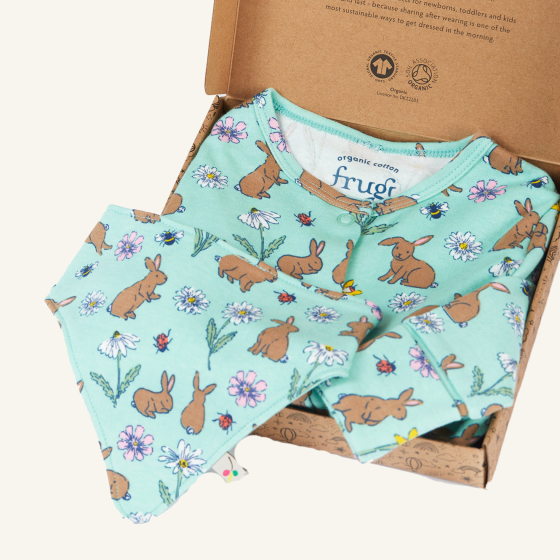 Frugi Organic Cotton Baby Gift Set - Riverine Rabbits. Made with GOTS Organic cotton, the set includes an all-in-one baby grow and a bib in a beautiful mint green fabric and bunny, flower, bee and ladybird print, inside a decorated cardboard box. On a cre