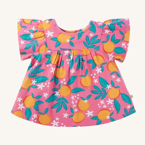 Frugi Organic Tessa Top - Orange Blossom. A soft and breathable, organic pink tunic-style cotton top with an all over orange blossom print, ruffle sleeves and loose gathering. On a cream background