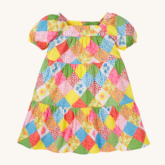 Frugi Children's Organic Cotton Shaya Tiered Dress - Patchwork. A beautiful summer dress with three colourful patchwork tiers, a square neck and short puffed sleeves. This colourful children's dress has an all-over patchwork design in floral prints and su