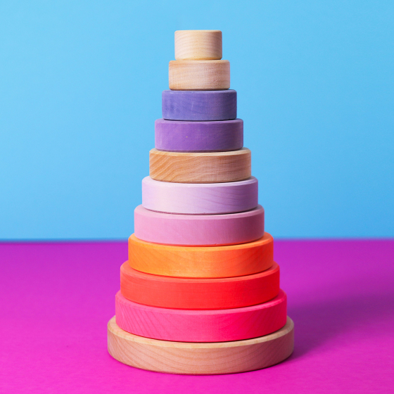 Grimm's Conical Stacking Tower - Neon Pink - On a plain blue background.
