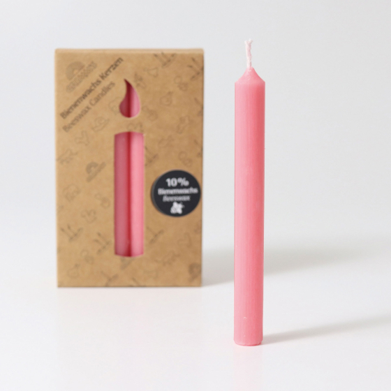 A pack of 12 Old Rose 10% beeswax candles by Grimm's with a single pink candle outside the box. White background.