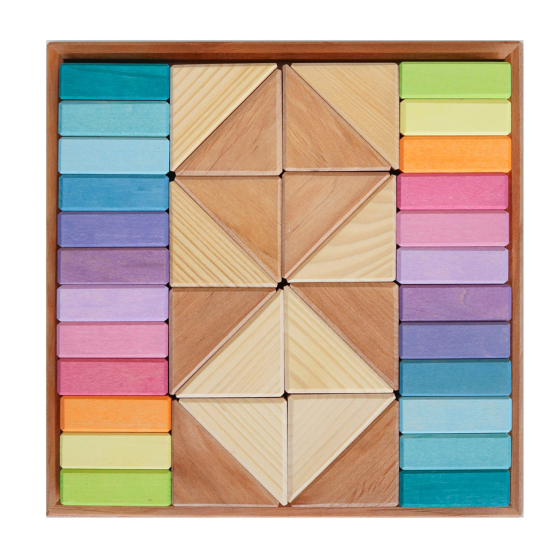 Grimms Wooden Pastel Duo Blocks, in a wooden tray. Natural Wooden Triangle blocks in the middle of the board, in light and dark wood, with colourful pastel blocks either side. On a white background