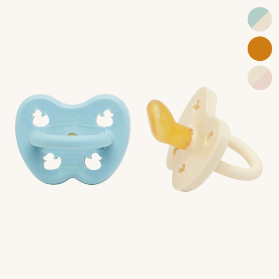 Hevea orthodontic natural rubber kids pacifiers on a beige background