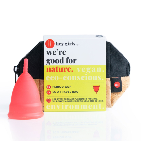 Hey Girls menstrual silicone cup in large in red next to it's travel bag on a white background