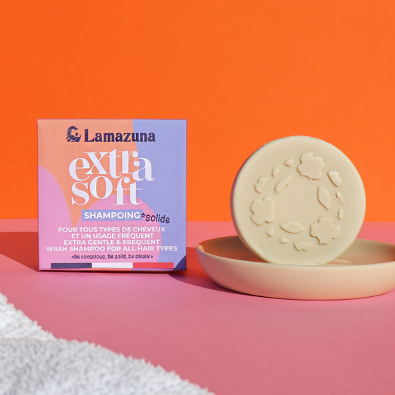 Lamazuna Extra Soft Organic Shampoo Bar for All Hair Types, in a cream dish and next to the box, on an orange background and pink table