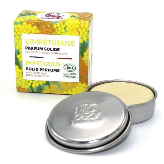 Lamazuna Impetuous Solid Perfume, product in tin pictured next to packaging on a plain white background
