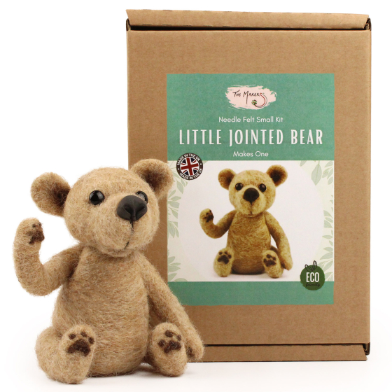The Makerss Needle Felt Jointed Bear. A beautifully crafted pose-able light brown bear, with a brown nose and black stick in eyes, sat next to its box