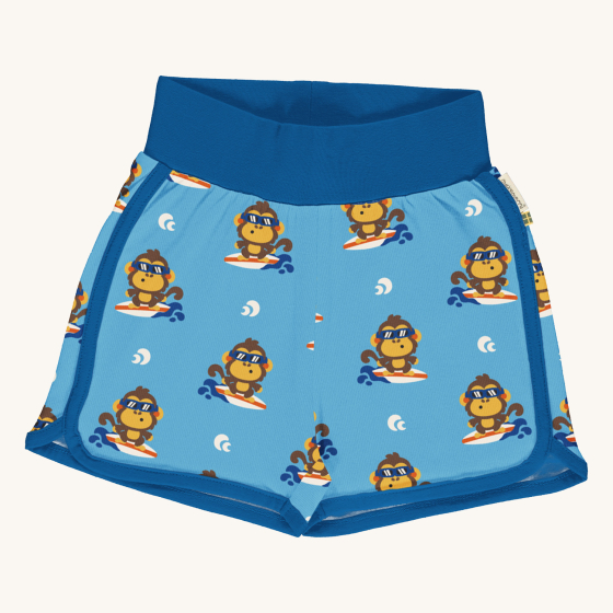Maxomorra Children's Organic Cotton Monkey Runner Shorts. A light blue fabric with surfing monkey repeated print, with navy blue piping on the side and bottom of the short leg, and a thick navy waistband