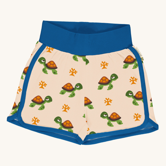Maxomorra Children's Organic Cotton Turtle Runner Shorts. A warm cream fabric with a repeated turtle and coral print, navy blue piping on the sides and bottom of the shorts, and a thick navy waistband