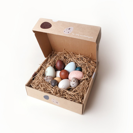 Moon Picnic plastic free wooden egg toys, nestled in a shredded cardboard nest inside a wooden cardboard box