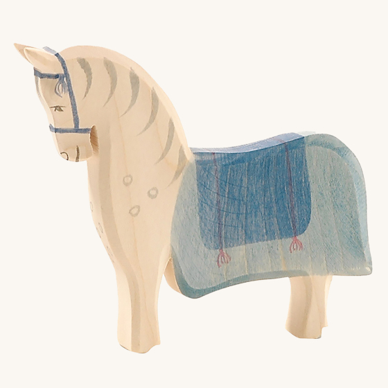 Ostheimer Wooden Horse Figure with a blue painted saddle, on a cream background