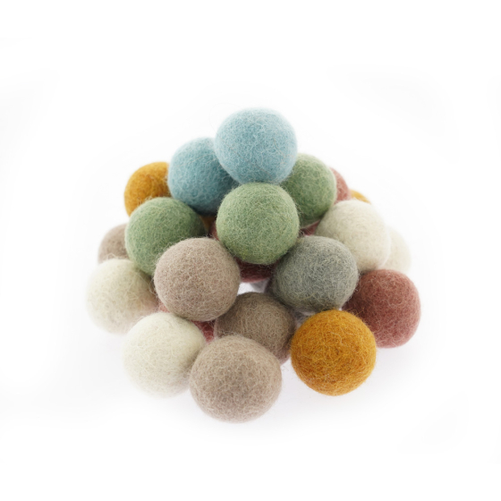 Pile of 29 Papoose handmade soft felt earth balls on a white background