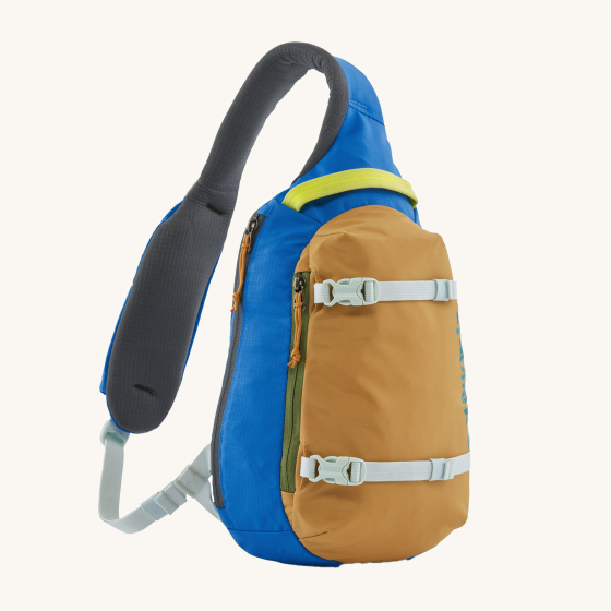 Patagonia Atom Sling 8L - Patchwork bag in Vessel Blue. Image shows the bag on a cream background