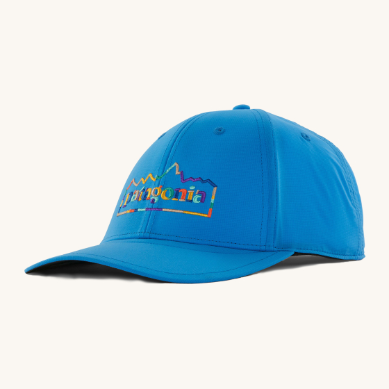 Patagonia Airshed Hat in Vessel Blue, with a colourful Patagonia logo at the front of the hat in rainbow colours. On a cream background