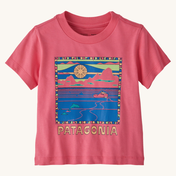 Patagonia Little Kids Graphic T-Shirt - Summit Swell / Afternoon Pink. A beautiful dusky pink t-shirt with a sunset image of dolphins and a boat sailing in the sea. The image has a pink, green, blue and yellow boarder