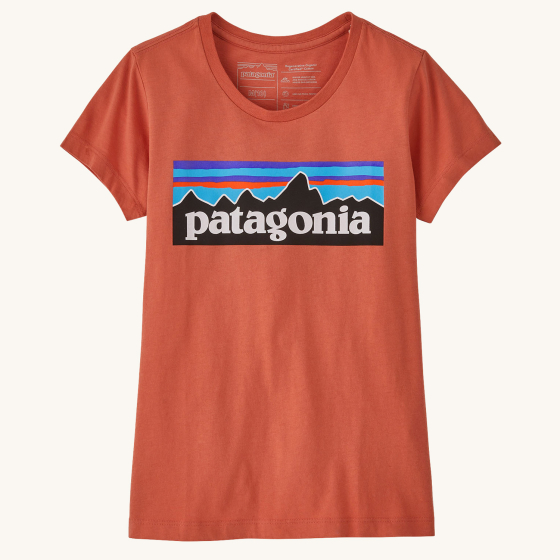 Patagonia kids organic cotton P6 logo t-shirt in the quartz coral colour on a beige background