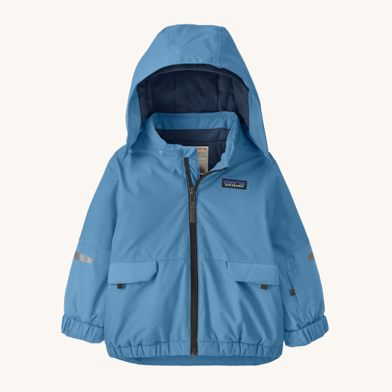 Patagonia Little Kids Snow Pile Insulated Ski Jacket - Blue Bird. This gorgeous Patagonia coat is solid powder blue in colour, with a removable hood and reflective stripes on the arms. Coat is set on a cream background