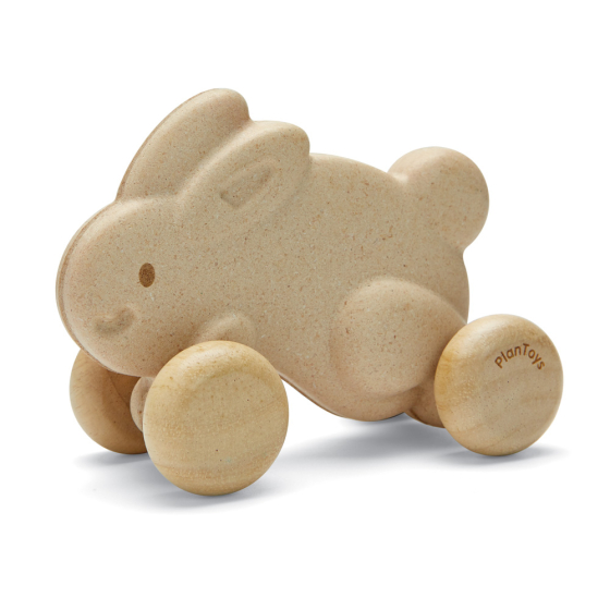 Plan Toys eco-friendly wooden push along bunny in white on a white background