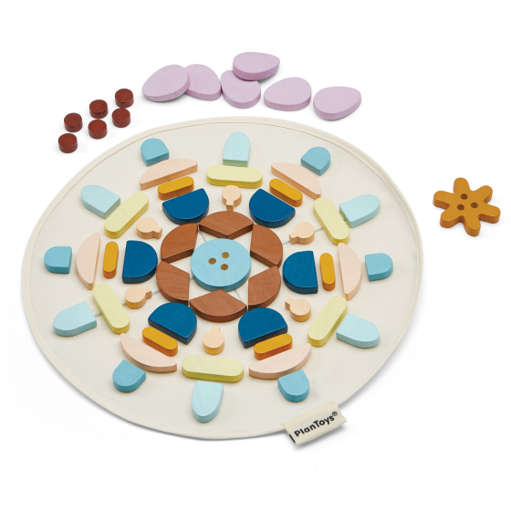 PlanToys kids wooden mandala toy blocks laid out in a pattern on a white background