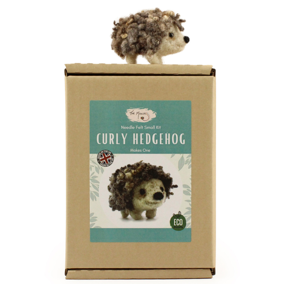 The Makerss Needle Felt Small Curly Hedgehog. A beautifully crafted curly haired hedgehog with a cute cream face and legs, a black nose and curly spines stood on top its box