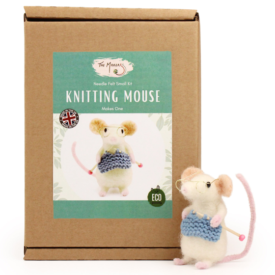 The Makerss Needle Felt Knitting Mouse. A beautifully crafted white mouse wearing glasses with a pink tail and feet, knitting a blue outfit and stood next to its box