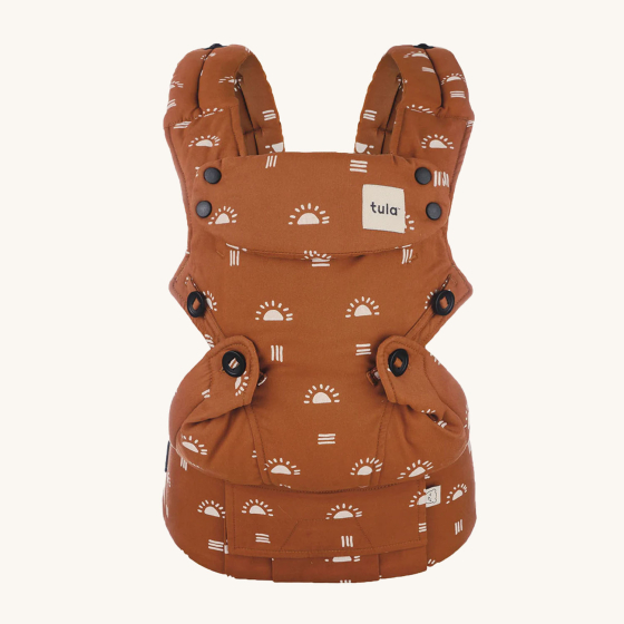 Tula Ergonomic Multi-Position Explore Baby Carrier 7-45lbs in Sedonia. Carrier is a burnt orange colour and playful sun and stripe patterns