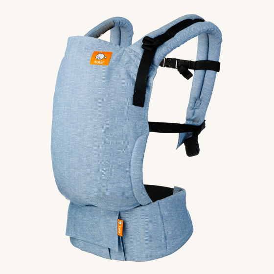Tula free to grow baby carrier in the rain blue colour on a beige background