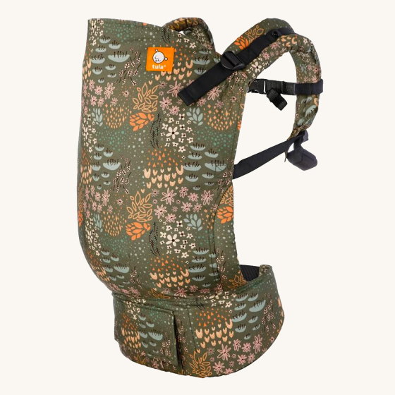Tula toddler baby carrier in the green meadow print on a beige background