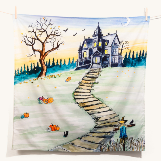 Halloween themed Wondercloths play cloth with haunted house, pumpkins, scarecrow, bats and moonlight. pegged onto a line against a white background