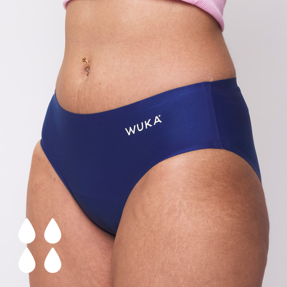 Picture of the WUKA Teen Stretch Seamless Period Pants in blue, worn by a model. An image of four white 'drops' indicates these pants are suitable for a heavy flow.
