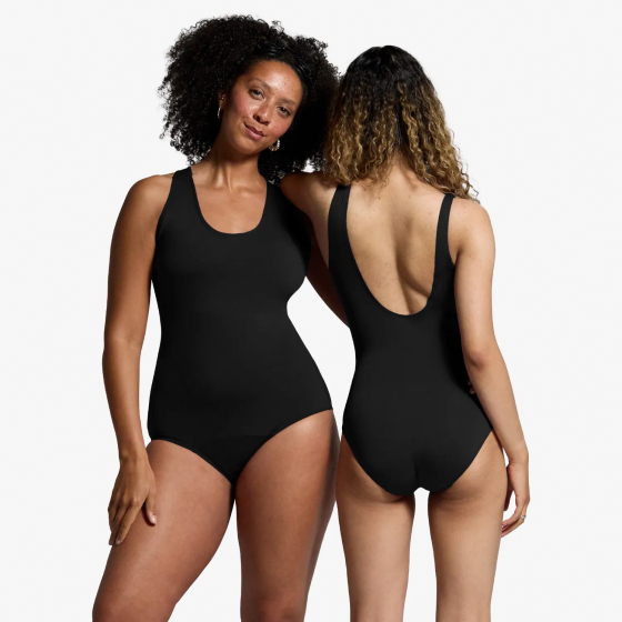 Two women model the WUKA Scoop Back Period Swimsuit - Light/Medium Flow. One model faces forward showing the front of the swimsuit and the other model faces backwards showing the scoop-back design.