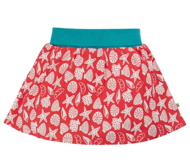 this two-in-one skort is a vibrant pink organic cotton jersey skirt with a beautiful white seashell print, layered over shorts with a stretchy fold-down blue waistband from frugi