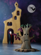 Bumbu Large Wooden Spooky Tree. A hancarved wooden toy in the shape of a spooky Halloween tree, with dying leaves and a sad grumpy face. With Bumbu Bats hanging from the branches, and Bumbu Dracular Vampire Wooden Toy in the back ground