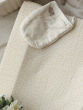 A close up of the Avery Row Baby Changing Cushion - Daisy Meadow with a towel bunny bath mitt placed on top. A delicate daisy print on a light coloured fabric. A comfortable changing cushion mat, with removable covers.