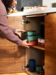 Person putting a stack of Klean Kanteen Rise Stainless Steel Food Boxes away in a kitchen cupboard