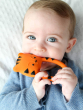 A baby holding and chewing on the Lanco Nalu the Tiger Teether 