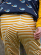 Child wearing the Little green Radicals Adaptive Extra Long Gold Striped Joggers showing the back of the trousers