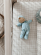 Olli Ella Lullaby Dozy Dinkum Doll - Leo is lying asleep on a checked sheet in a cot.