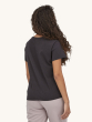 A person wearing the Patagonia Women's Regenerative Organic T-Shirt - Ink Black, showing the back of the t-shirt with grey trousers