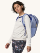 Person wearing the Patagonia Recycled Black Hole Backpack 25L in Pale Periwinkle, front side view, on a cream background