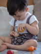 Child Concentrating on putting in Yellow PlanToys Wooden Nuts and Bolts Puzzle Ball bolt into a wooden Sphere