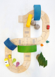 Plan Toys Standard Road System pictured from above with pieces of a Grimm's rainbow used as tunnels and bridges over the road 