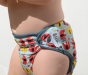 Close up of baby wearing the close babipur reusable popper nappy on a white background