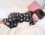 Girl laying on a white bed wearing the Maxomorra lightning print pyjama set